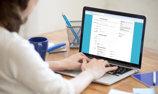 En dame med laptop ser på et påmeldingsskjema